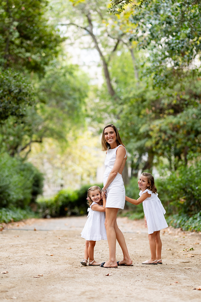 Madre con sus hijas posando sonrientes en parque de Barcelona