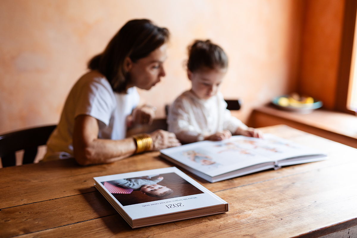 Abuela y nieta miran álbumes de fotos en el comedor