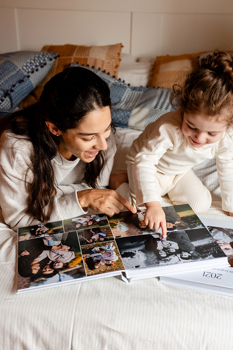 Mamá y niña miran un álbum de fotos de familia