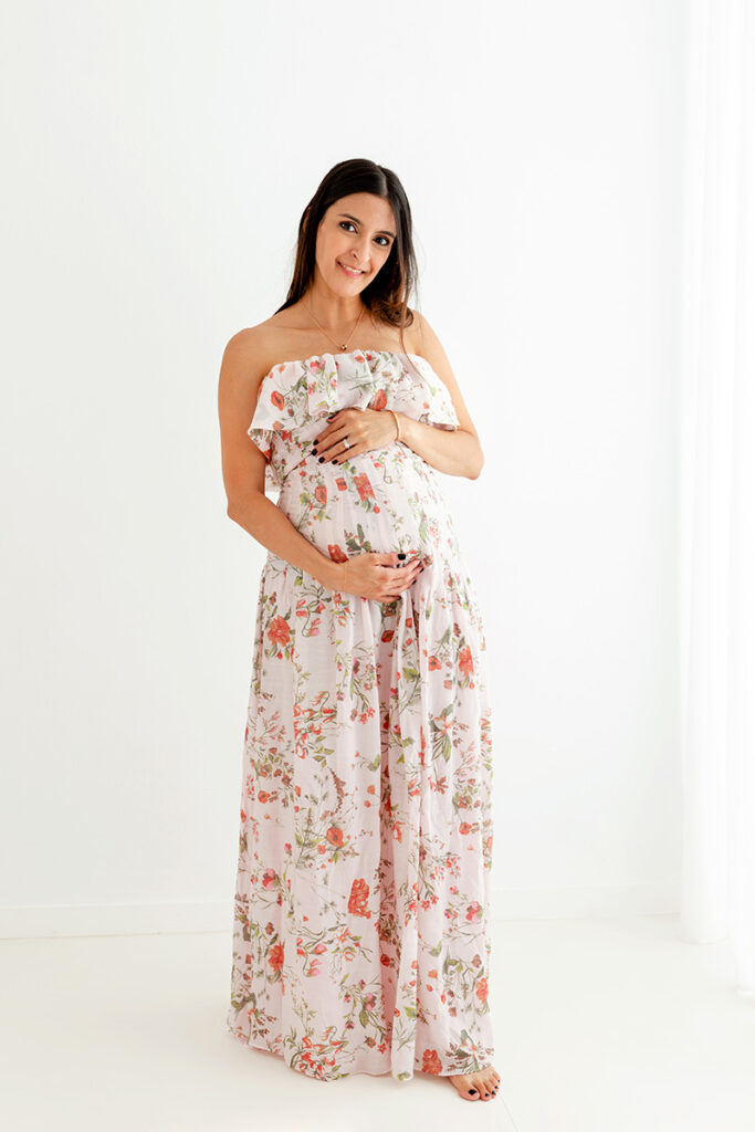 Mujer embarazada con vestido de flores largo fluido