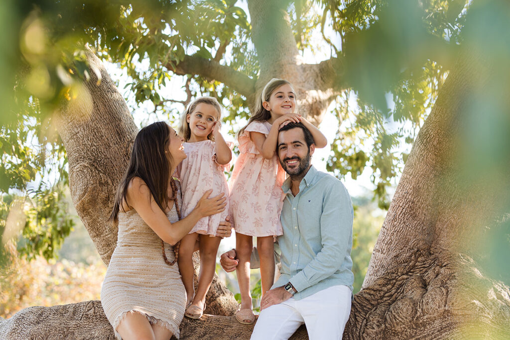 Familia sentada en un árbol gigante en un parque de Barcelona
