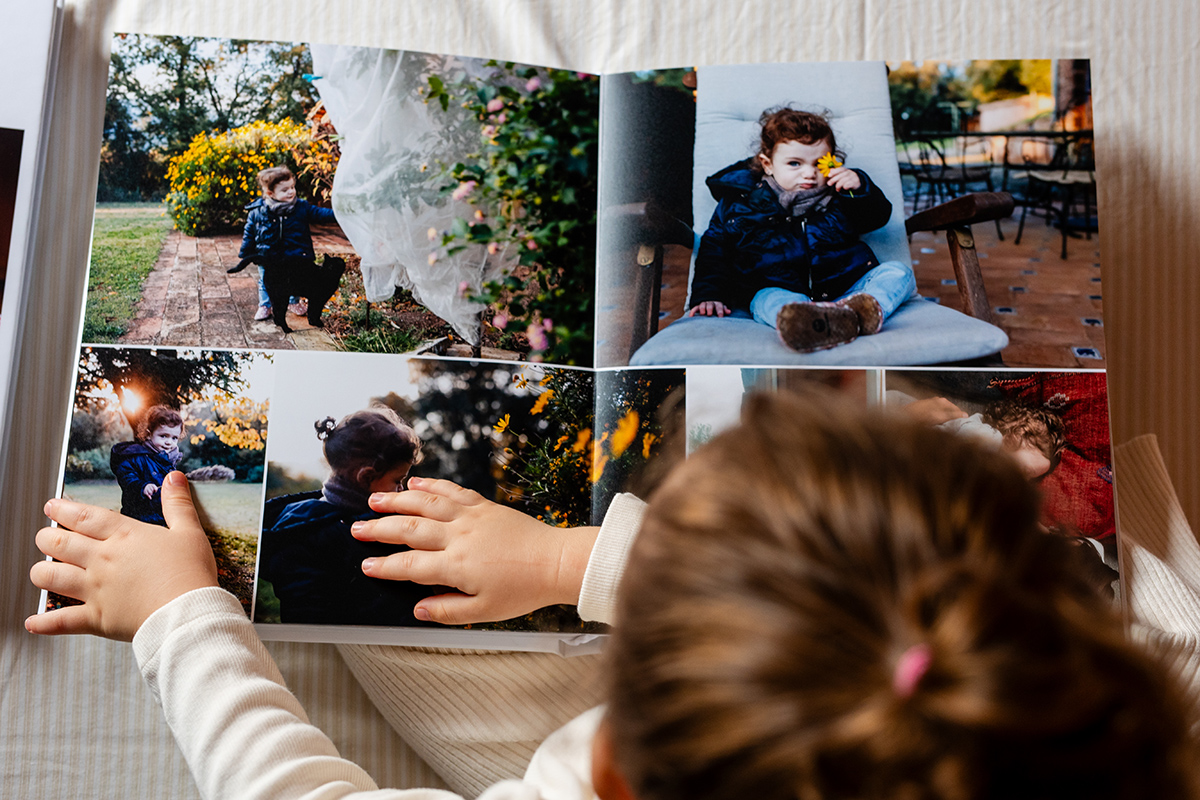 Manos de niña pequeña pasan las páginas de un álbum de fotos