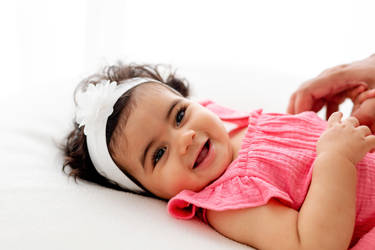 Bebé de 8 meses sonriendo en su sesión de fotos en estudio
