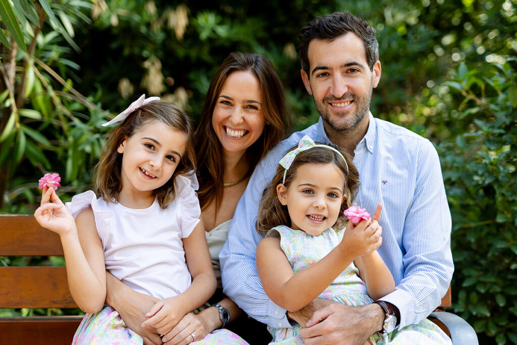 Familia sentada en un banco en un jardín de Barcelona