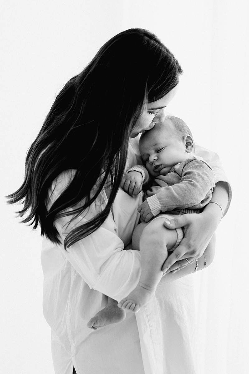 Madre con bebé en brazos en fotografía muy tierna en blanco y negro