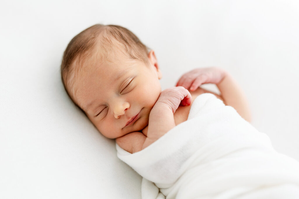 bebé recién nacido dormido y sonriendo